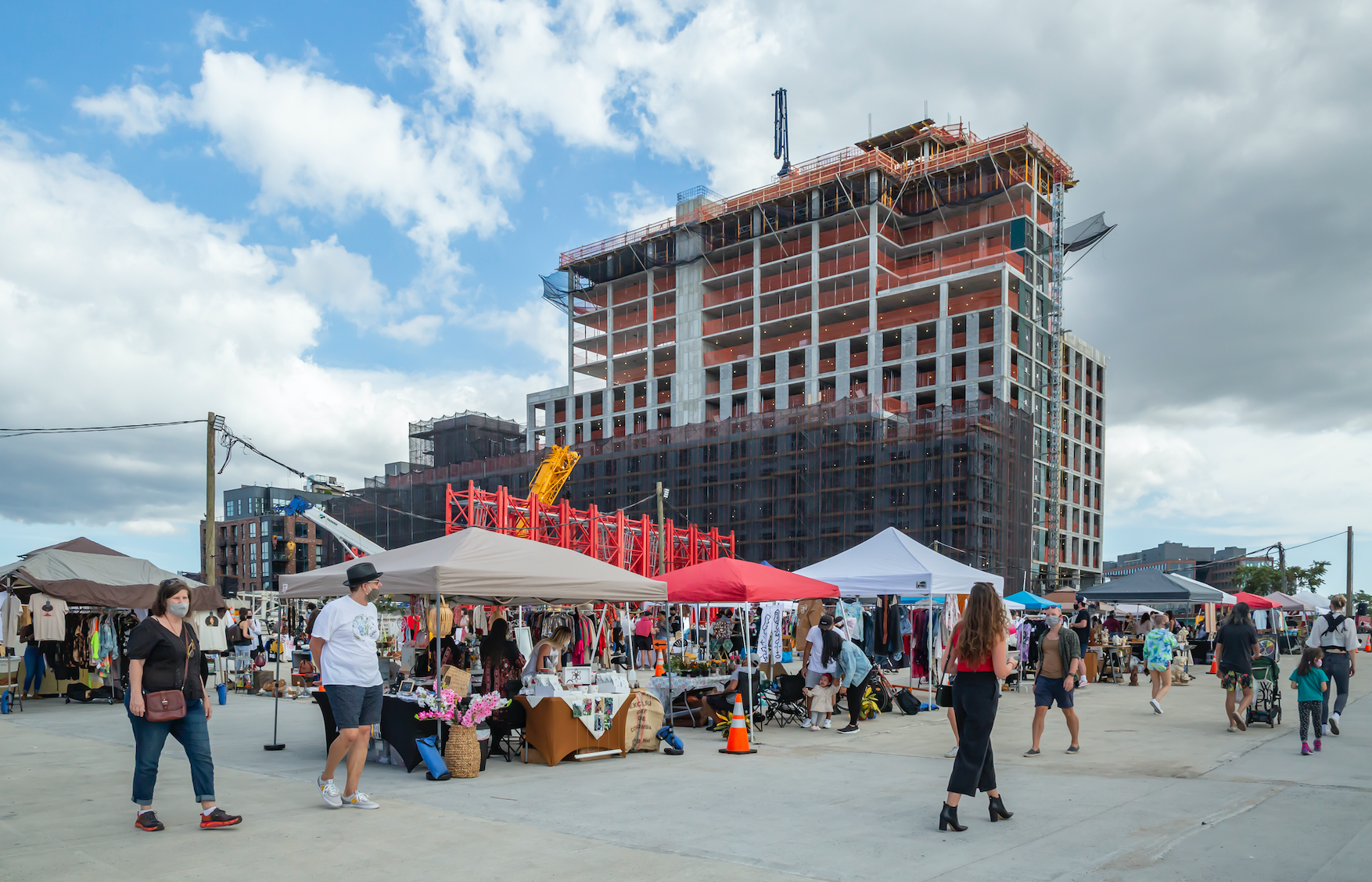 People walking to outdoor vendors at the Greenpoint Terminal Market near 1 Kent Boutique Condo